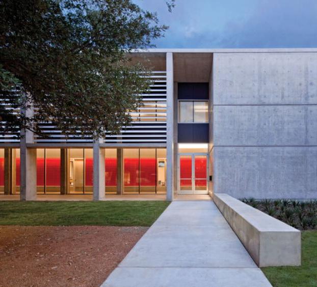 A view of Equity Hall and its courtyard at dusk, 里面的红色墙壁被走廊的灯照亮了.