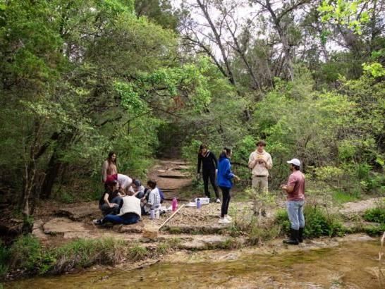 A class conducts research in a creek at Wild Basin.